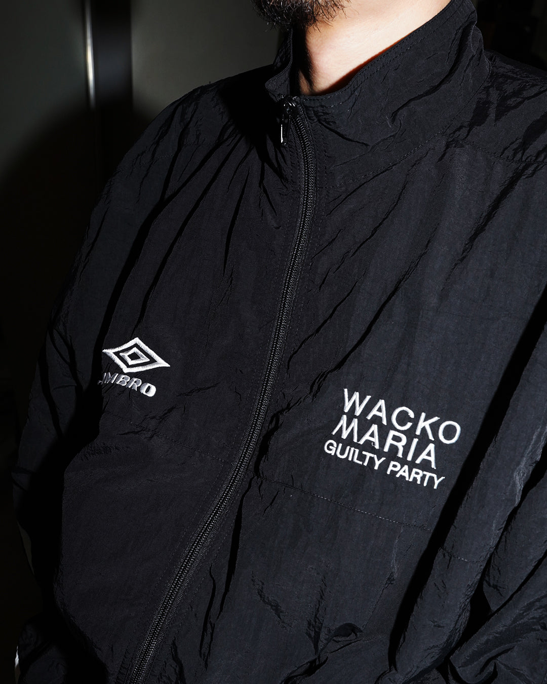 Umbro × Wacko Maria FW26 black nylon track jacket on model with dual chest logos