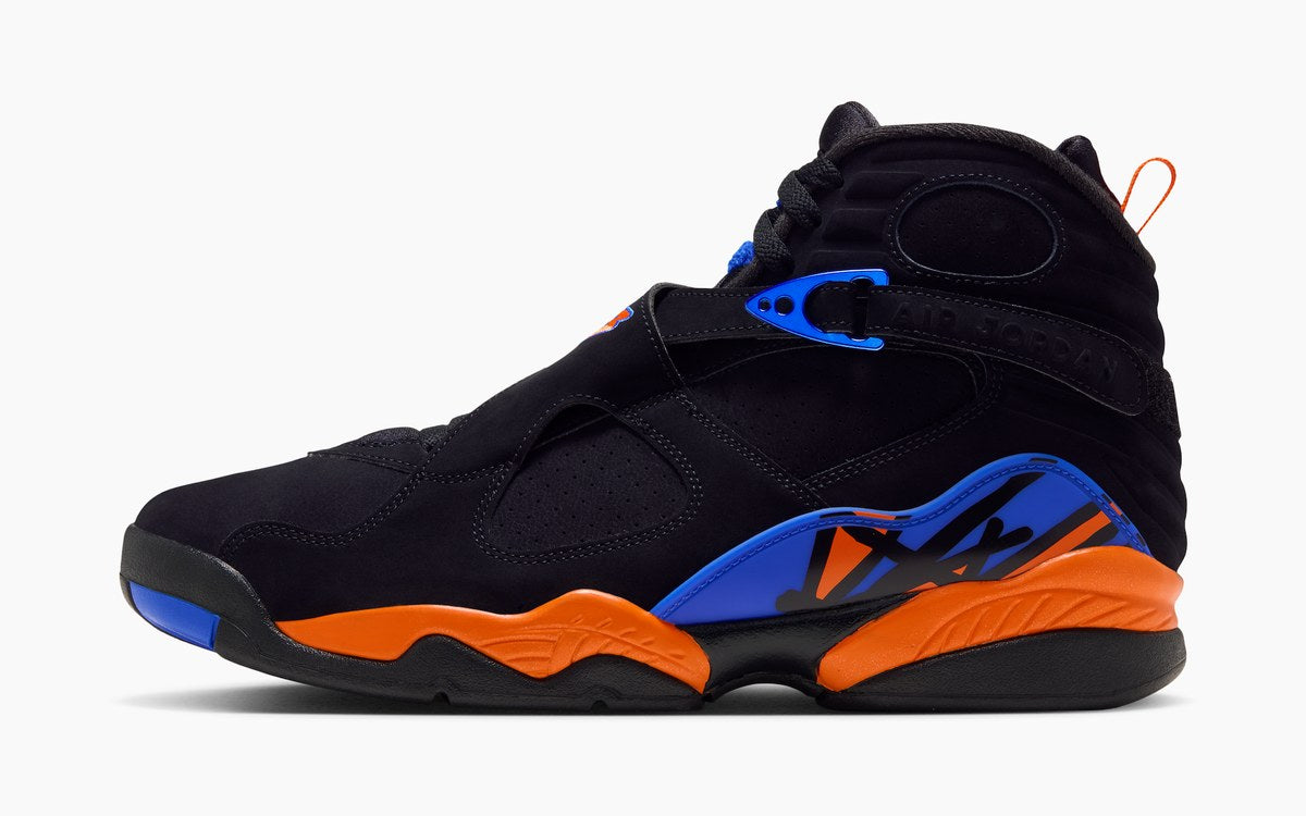 Side view of the Air Jordan 8 Knicks IX8479-010 in black with royal blue and orange accents and an orange midsole. Photo via Nike