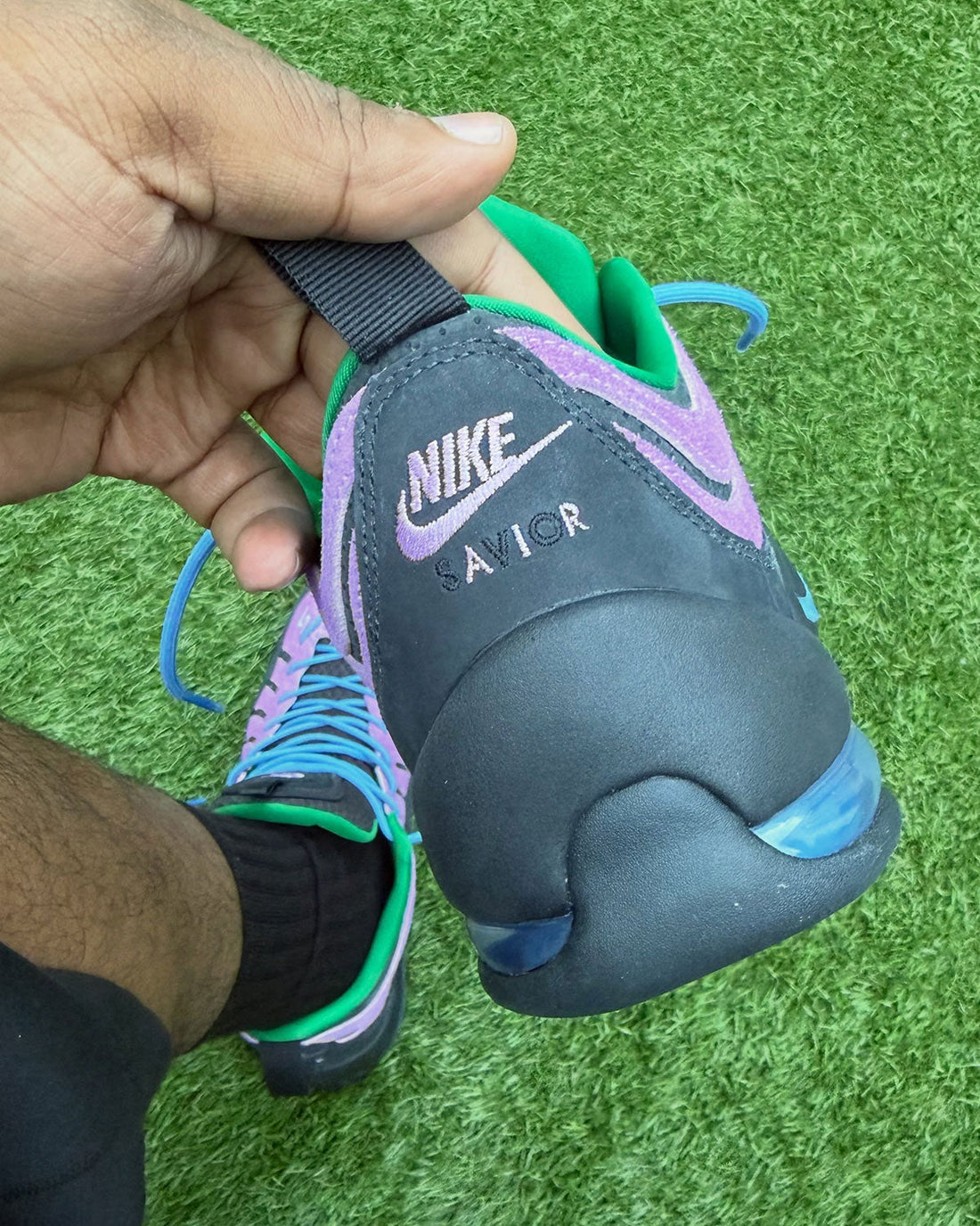 Jae Tips × Nike Air Bakin Low Savior — on-foot heel with SAVIOR embroidery on green turf