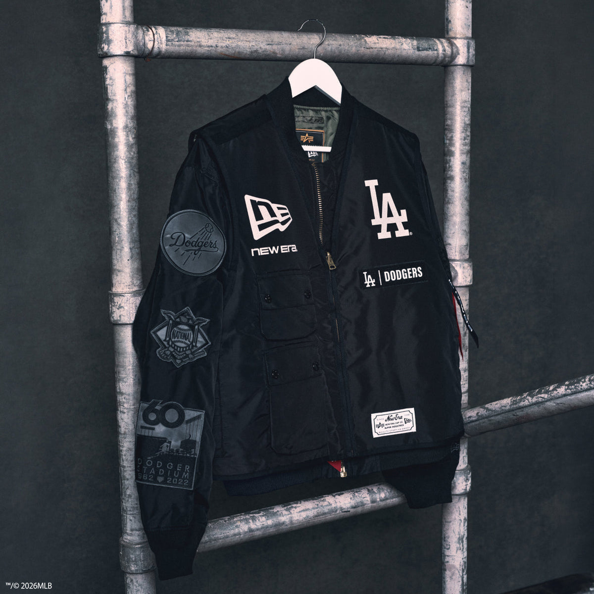 New Era × Alpha Industries MLB Dodgers MA-1 bomber on industrial hang — courtesy New Era Japan